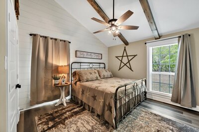 Master bedroom with King size bed in this three-bedroom, two-bathroom rental farmhouse near Lake Waco, golf courses, and 15 minutes to downtown Waco & Baylor.