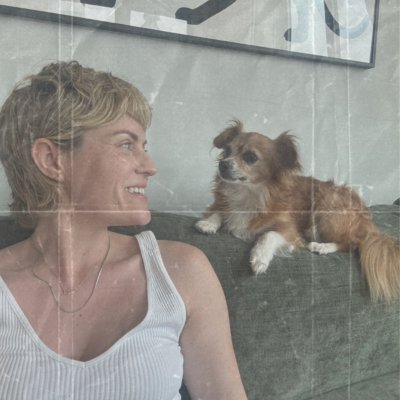 Nyc Psychiatrist, Laura Temple, smiles at her chihuahua mix, Mouse, who sits atop sofa