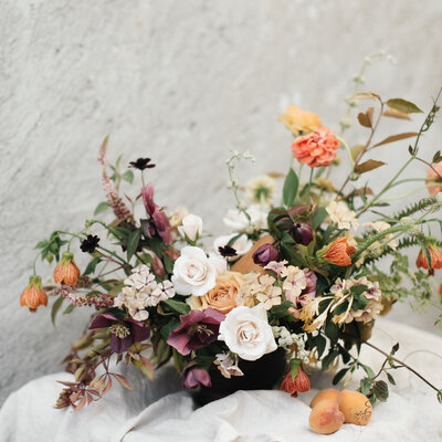 A beautiful, organic arrangement of deep purple and peach flowers at a Montreal wedding. 