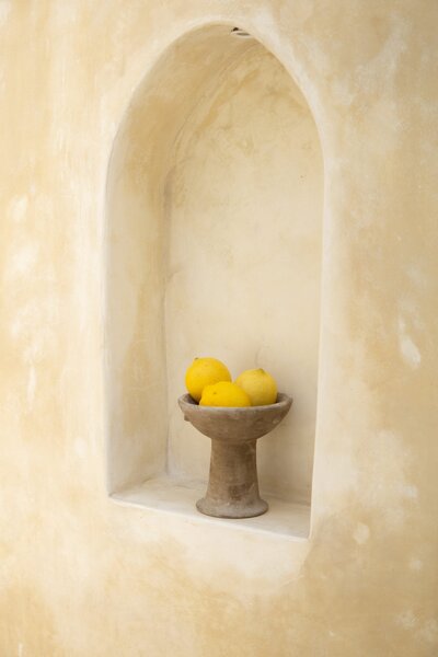 Amare Mockup Shop: Stock photo featuring a bowl of lemons elegantly placed on a wall niche, creating a fresh and vibrant visual appeal.