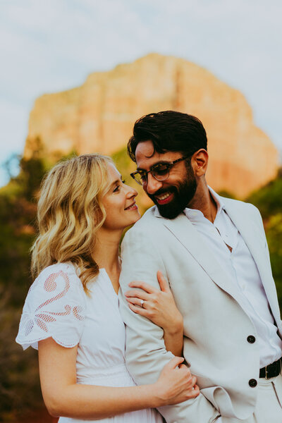man and woman hug for engagement pictures in sedona
