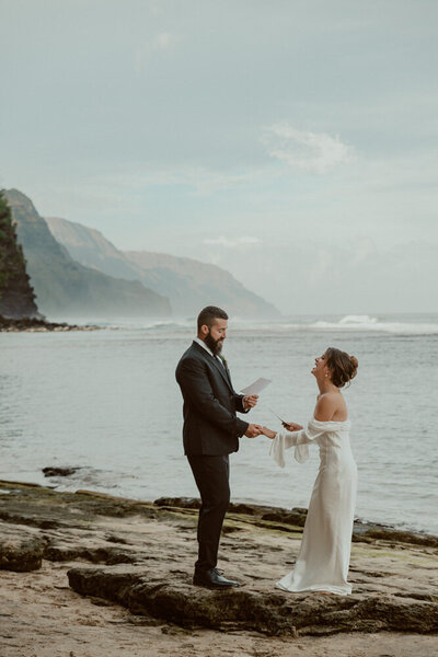 bride and groom exchanging vows on a beach in kauai