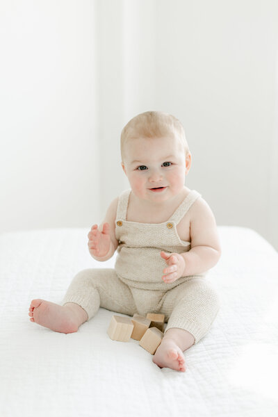 1 year old boy sitting on a white bed in Charleston Portrait Photography studio