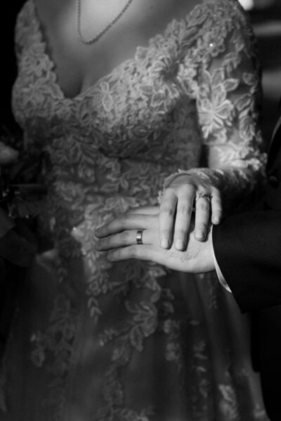 Close-up of the bride and groom's hands with their wedding rings in focus