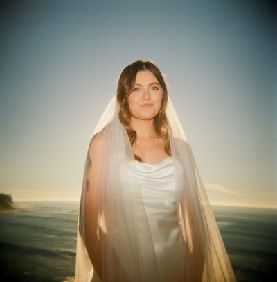 bride wearing veil in the golden sunlight taken by luxury destination wedding photographer Noble Photo Co