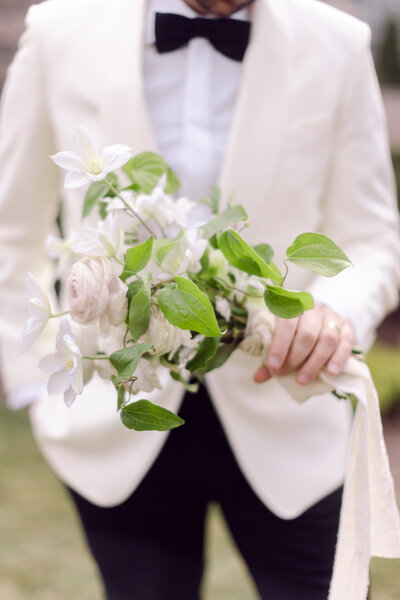Groom holding a bridal bouquet
