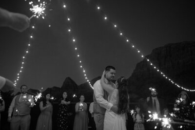 couple dancing under string  lights and Zion cliffs 