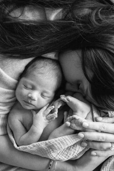 mum snuggled into newborn