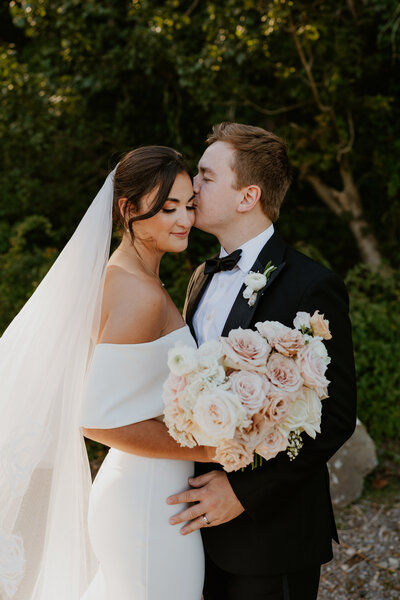 groom kissing bride on her head