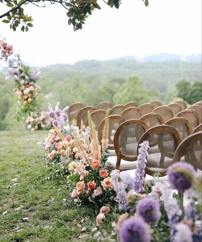 Ceremony aisle with peach and lavender colored flowers