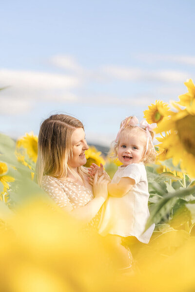 mum and daughter having family photos taken in sunflower field near Brisbane area.