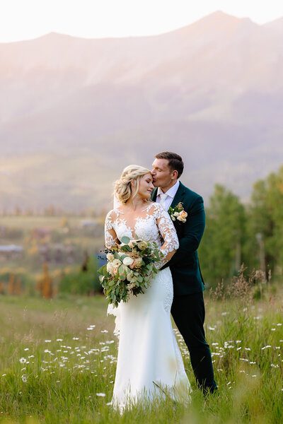Adventure elopement couple kissing at sunset overlooking epic mountain views in Telluride Colorado. 