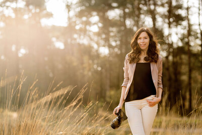 Vrouw bij de Ginkelse Heide voor een bedrijfsshoot als fotograaf met haar camera in de hand