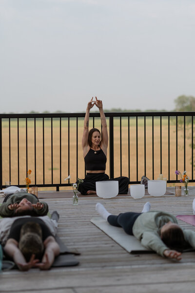 Yoga instructor leading students in tabletop position with one leg extended, focusing on balance, core strength, and mindfulness.