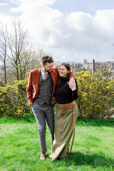 cozy Edinburgh engagement photo of a couple walking on Calton Hill