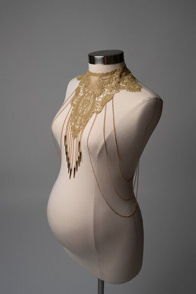 Pregnant woman wearing a statement pearl shoulder piece in a fine art maternity photo