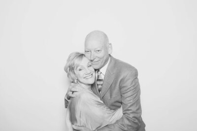 A couple hugs and smiles at the Birdie Booth camera, representing an image taken by a Eugene photo booth rental for weddings and events.