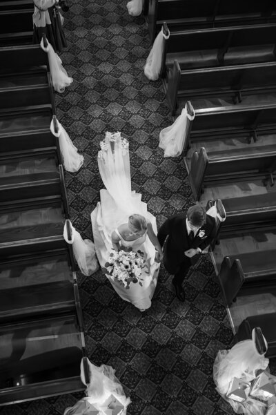 overhead view of bride and groom recessing down church aisle