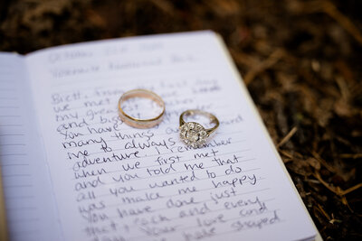 Private vows written in a small notebook with lines. The wedding rings have been placed on top.