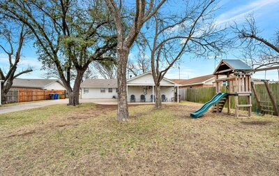 Spacious backyard with playset in this Entry way of this three-bedroom, two-bathroom vacation rental home featured on Chip and Joanna Gaines' Fixer Upper located in downtown Waco, TX.