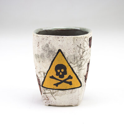 A ceramic cup that resembles plaster falling apart from red bricks with painted cacti and graffiti