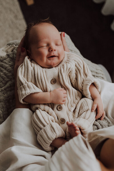 Newborn baby in cream knit outfit