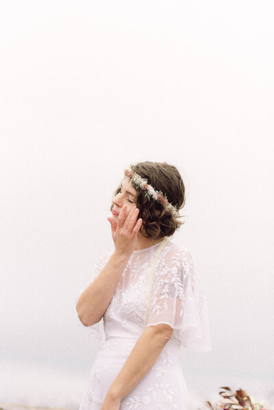 Bride in lace gown standing at mountain overlook during Virginia elopement, captured in nostalgic editorial film style.
