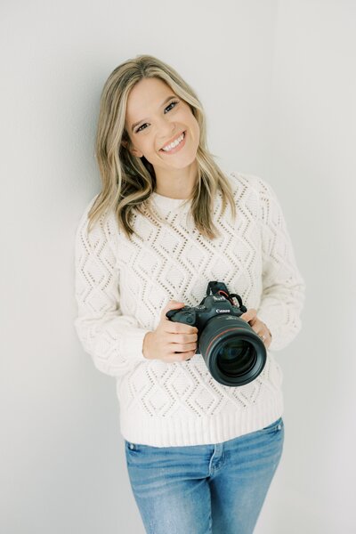 Kimberly smiling while holding a camera