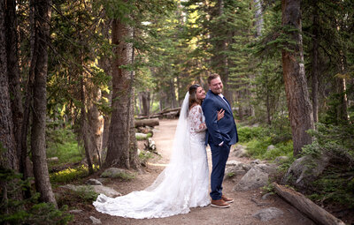 wedding couple walking hand and hand with a mountain scene behind them including a gondola overhead