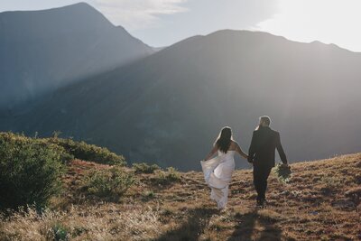 Wedding and Elopement Photography, Bride and Groom run through mountains during Colorado elopement.