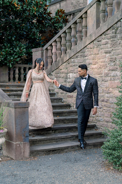 Indian Bride and groom, groom is leading bride down steps