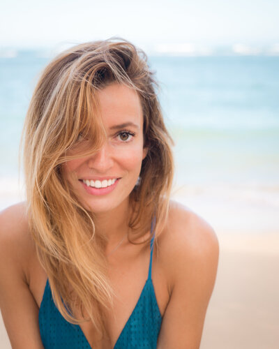 Jess of Jess Wandering in a blue tank top at a beach