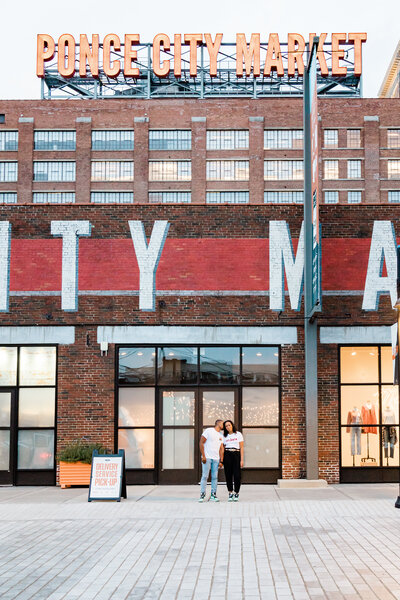 Atlanta New York couple poses for engagement photos in front of Ponce City Market.
