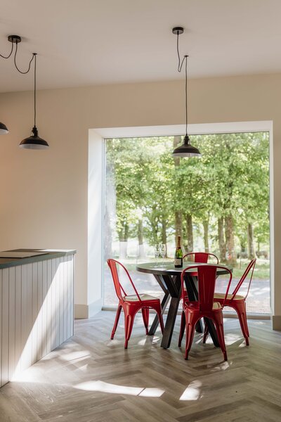 A wide photograph of a modern cottage kitchen with views out to the woods at Kinclune House.