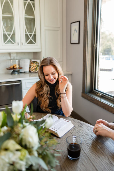 JaCee Petko, Christian life coach, sitting at a table with her Bible