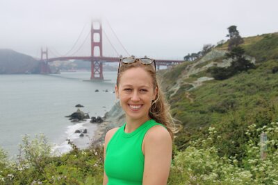 Emily standing in front of the Golden Gate Bridge, smiling