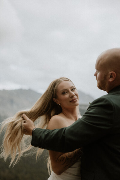 bride and groom walking together in front of mountains in montana during their elopement