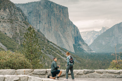 Hiker is on one knee  proposing to his girlfriend at tunnelview in Yosemite national park