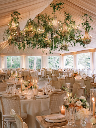 Wedding reception table close up with a teal patterned scalloped plate, wooden cutlery, and white flowers