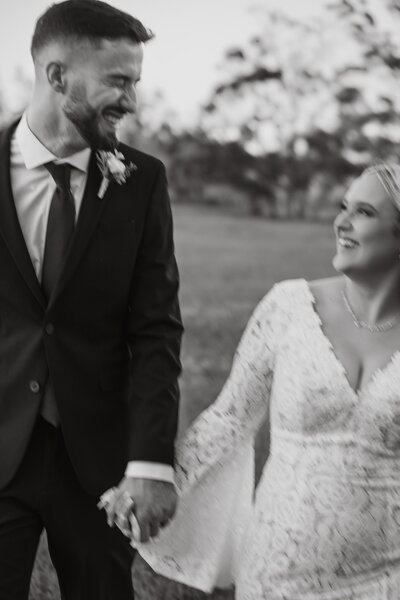 couple holding hands laughing together on their wedding day