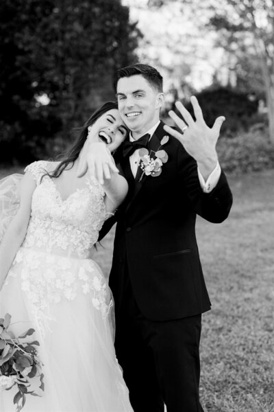 happy couple smiling showing of their new wedding bands