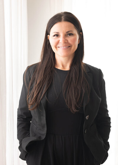 leadership coach in all black professional attire with hands in pockets
