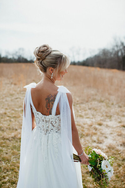 Bride with a voluminous, textured high bun — chic updo perfect for outdoor Maryland weddings by Klover Beauty.