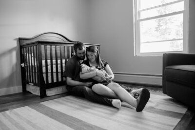 Black & White Photo of Parents staring down at Newborn Baby