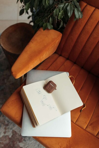 Orange chair with journal and green plant