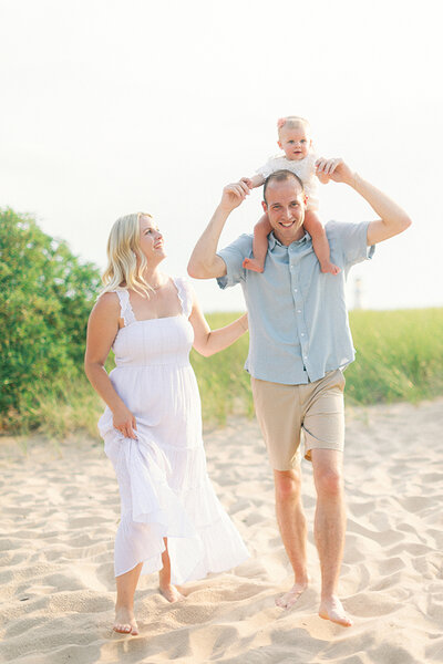 baby on dads shoulders with mom walking