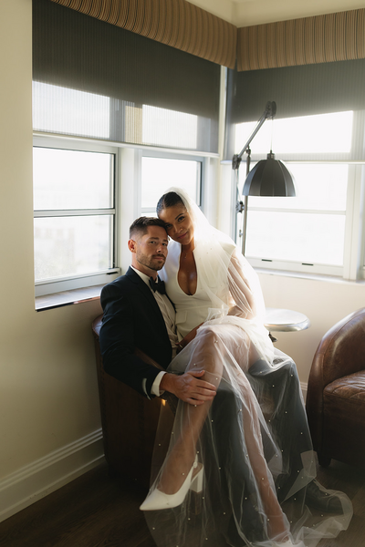 Newlywed couple sitting in a corner of their wedding venue enjoying their reception | Sush Digital Media