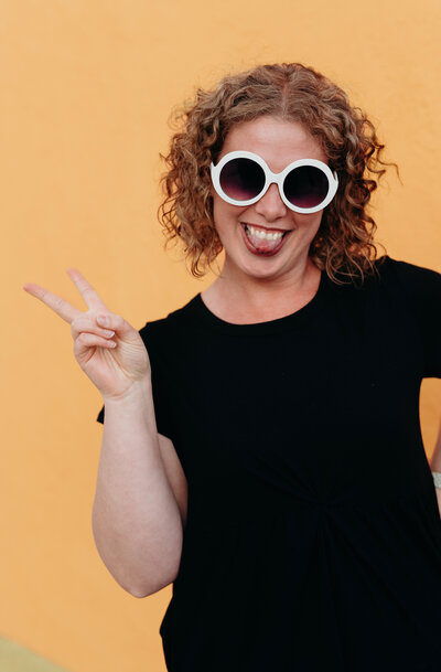 A woman member of the LIVE BIG Collective posing confidently with sunglasses on 
