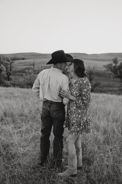 Outdoor couples photo session in Wyoming, featuring a romantic moment with a couple and their horses in a scenic rural setting with soft natural light.