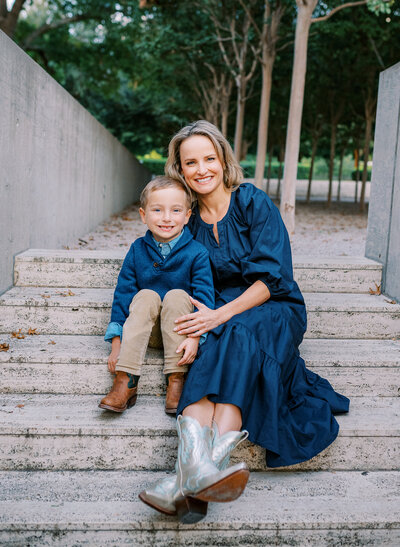 Mom and her young son are sitting on the steps, snuggled together during an outdoor photo session in Fort Worth.